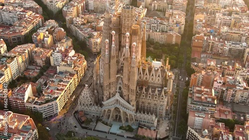 Aerial view of Barcelona City Skyline and Sagrada Familia Cathedral. Flying around the architectural masterpiece of Gaudi at sunrise golden hour