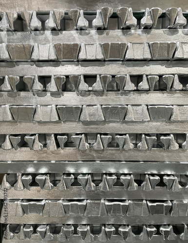 front view of aluminium alloy ingots stacked in the foreground, high-pressure die casting material, raw material, resources for the automotive industry, vertical