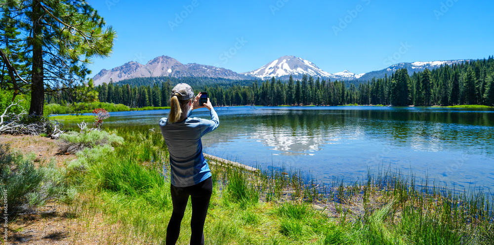 Φωτογραφία Panoramic of woman taking photo of Mt Lassen reflected in Manzanita Lake