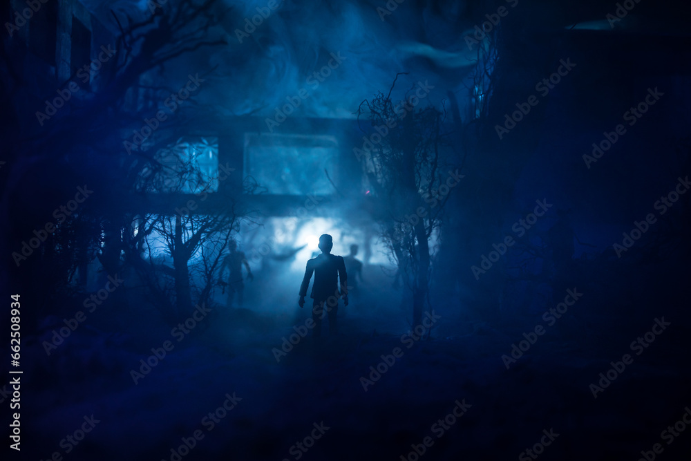 Fototapeta premium Silhouette of person standing in the dark forest with light. Horror halloween concept.