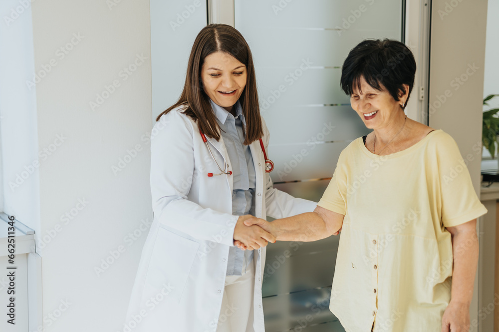 Fototapeta premium Doctor visits elderly woman at clinic, analyzing diagnosis and discussing medical results. Patient receives treatment and professional care.