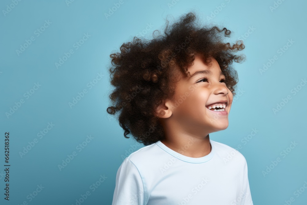 Portrait of a cute african american little boy with curly hair on blue background Portrait of a cute african american little boy with curly hair on blue background