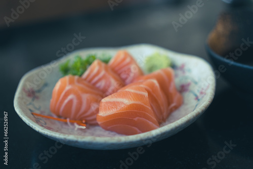 Delicious sashimi salmon served with wasabi on white dish. Selective focus