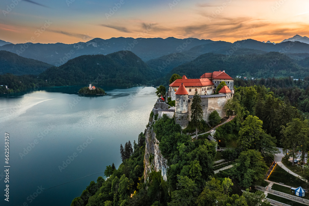 Bled, Slovenia - Aerial panoramic view of beautiful Bled Castle (Blejski Grad) with Lake Bled (Blejsko Jezero), the Church of the Assumption of Maria and colorful sunset sky over Julian Alps