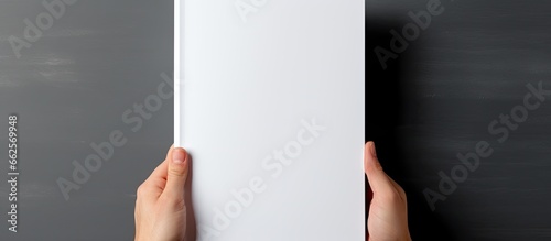 Mockup of a blank white journal being held displaying a softcover A4 book with clear magazine template With copyspace for text photo