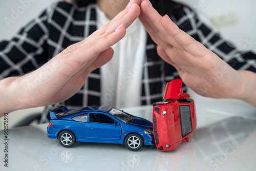 Close up of female hand protecting small toy car at office