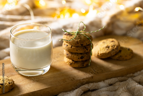 Close up of glass of milk and christmas cookies with copy space on wooden background