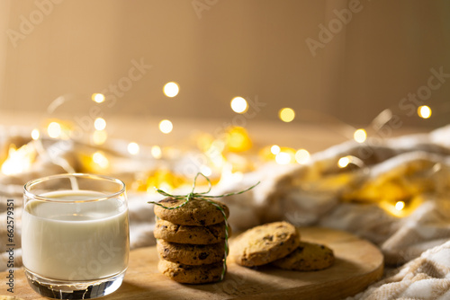 Close up of glass of milk and christmas cookies with copy space on wooden background