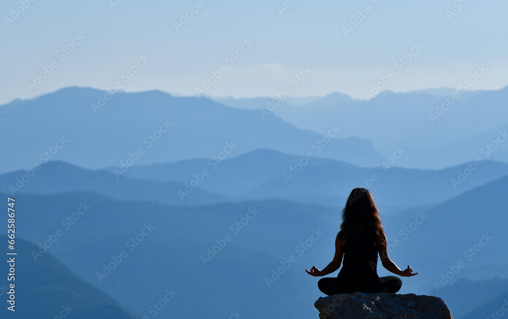 Silhouette of a Young Woman Practicing Yoga in a Beautiful Landscape