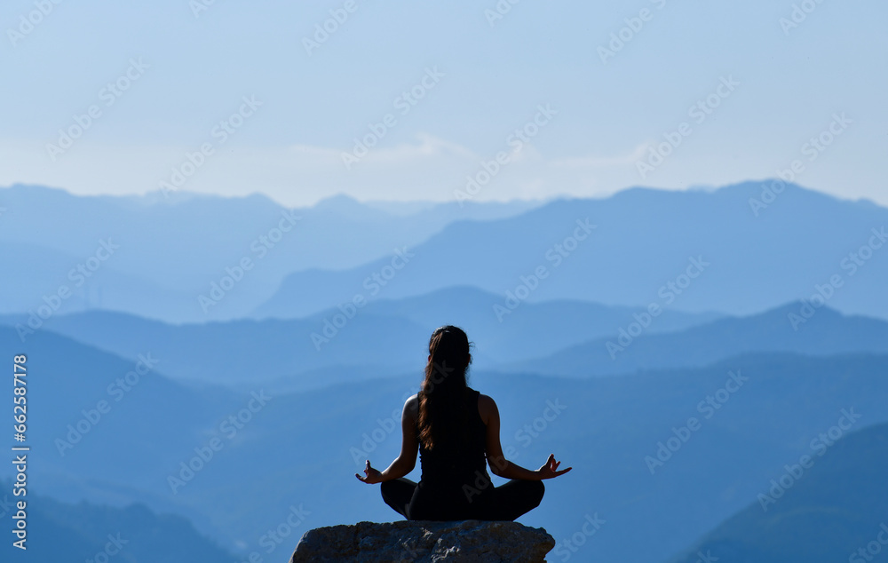 Silhouette of a Young Woman Practicing Yoga in a Beautiful Landscape