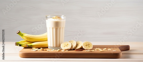 Banana peanut butter smoothie on a wooden cutting board With copyspace for text