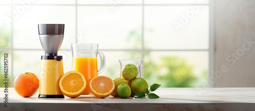 Contemporary juicer and citrus fruits with juice on kitchen table With copyspace for text
