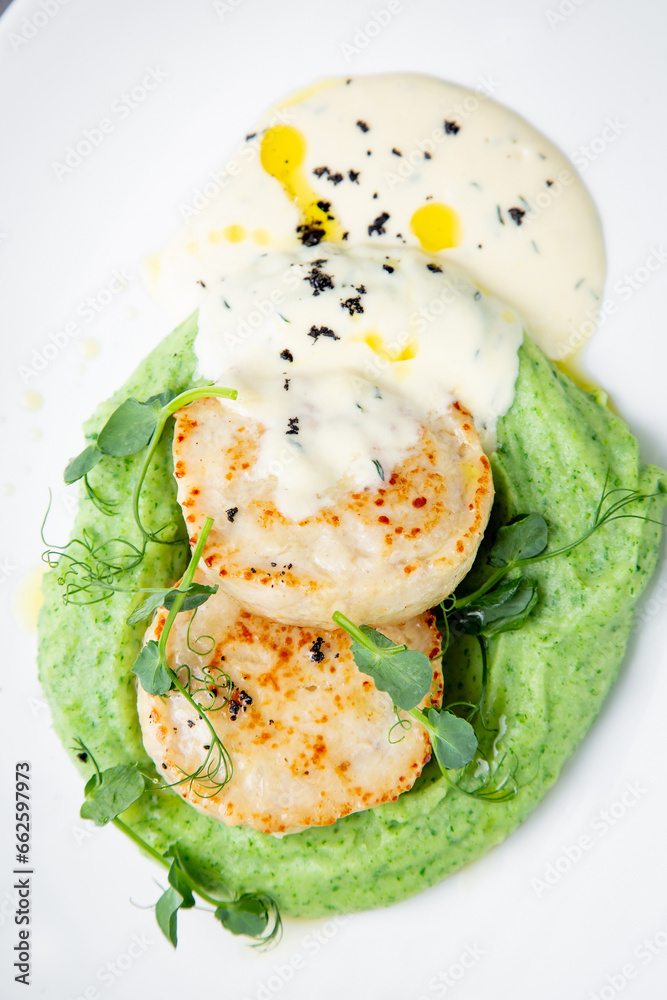cheesecakes with creamy sauce on broccoli puree, top view cheesecakes with creamy sauce on broccoli puree, top view