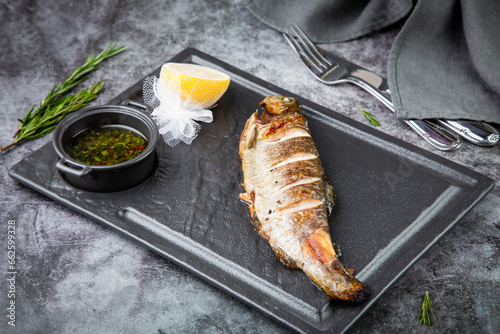 baked fish with broth and lemon, side view