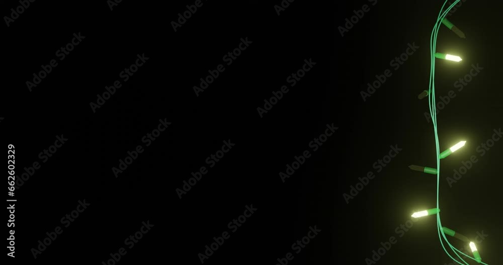 Strand of yellow christmas string lights flashing on black background, copy space