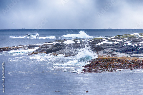 Ocean Waves, Splashes On Roaring Water on Beach At Lofoten Islands in Norway.
