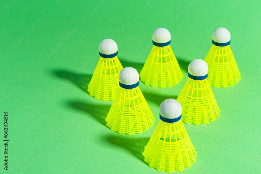 View of Line of New Shuttlecocks on Green Background As Flatlay with Copy Space.