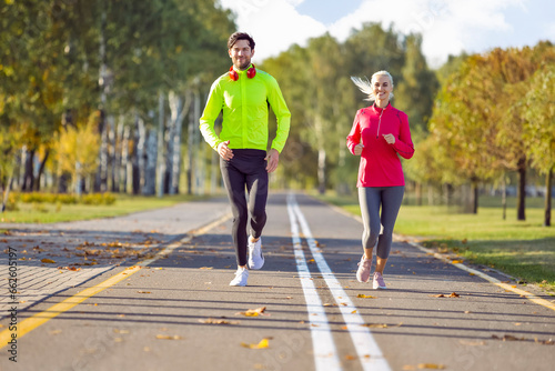 Running Sport Concepts. Positive Running Couple During Happily Jogging Outside as Runners Training Outdoors Working Out in City As Fitness Couple. photo