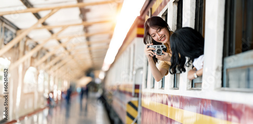 Happy smiling woman taking photo with her friend from window train, traveling by train
