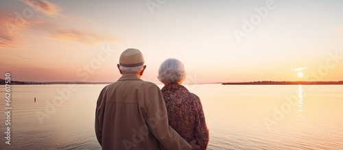 Elderly couple enjoying romantic sunset by the sea With copyspace for text
