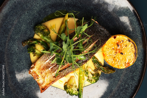 Tableau sur toile Fried dorado fish and mashed potato on a black plate