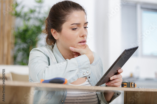 upset young woman checking a tablet photo