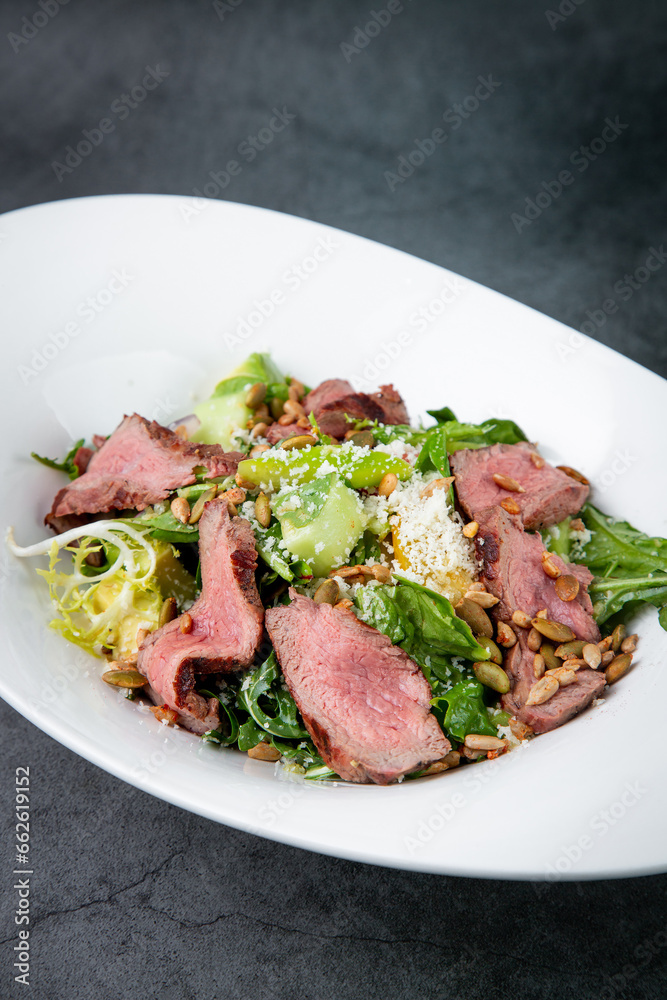 salad with pieces of beef, pistachios, lettuce and cheese side view salad with pieces of beef, pistachios, lettuce and cheese side view