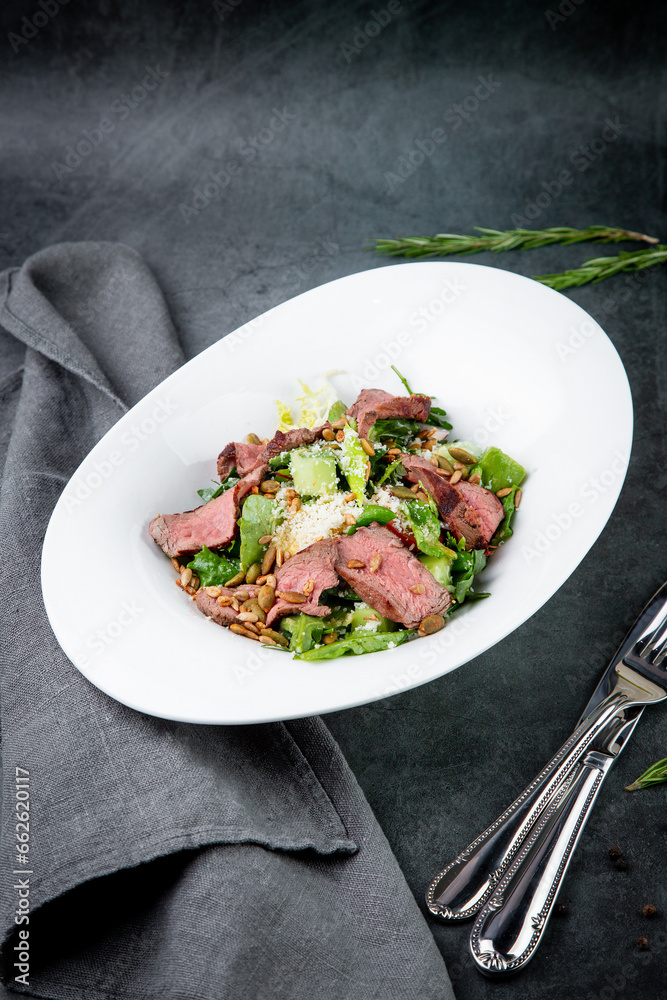 salad with pieces of beef, pistachios, lettuce and cheese side view salad with pieces of beef, pistachios, lettuce and cheese side view