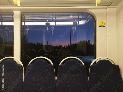 Reflection of a woman taking a photo of an empty metro at sunrise, Florence, Tuscany, Italy photo