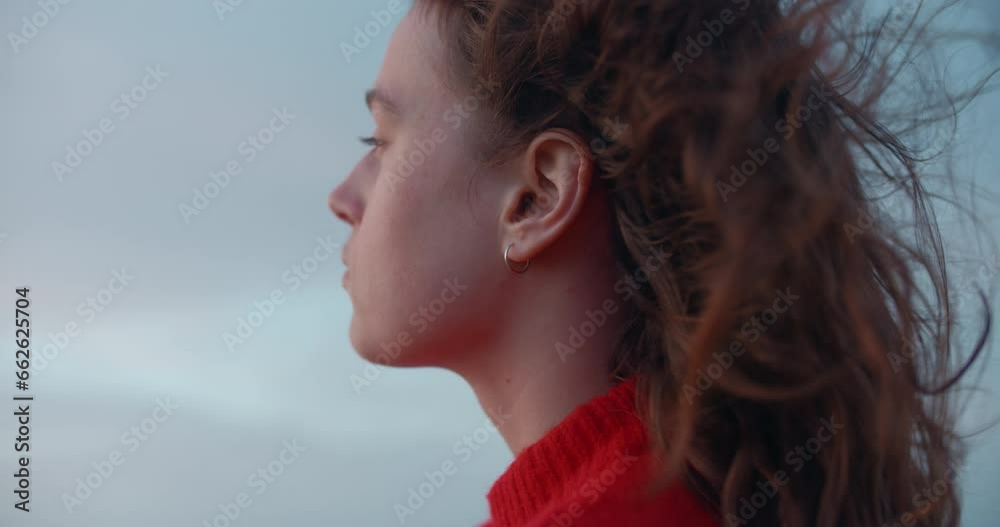 Portrait of young beautiful woman look pensive into distance. Strong ocean breeze or sea wind blow her hair. Free and youthful new generation. Cinematic real people, empowered woman Portrait of young beautiful woman look pensive into distance. Strong ocean breeze or sea wind blow her hair. Free and youthful new generation. Cinematic real people, empowered woman