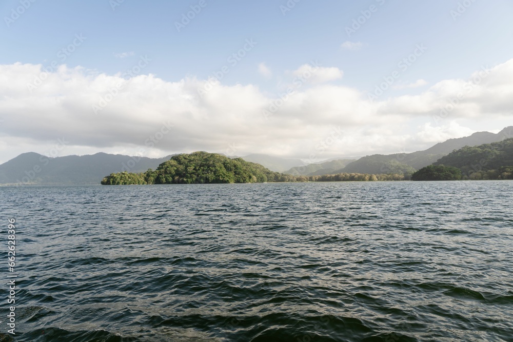 Tranquil lake nestled in a lush, green forest with a majestic mountain in the background