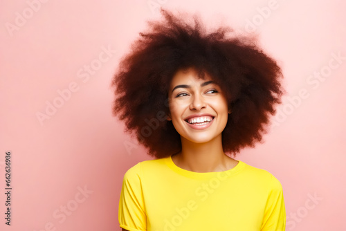 Woman with afro smiling and looking up at the camera. © valentyn640