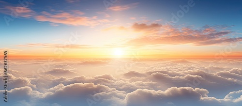 Bird s eye view of dynamic sunset over thick white clouds with far off mountains on the horizon With copyspace for text