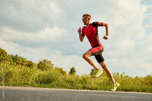 Fotografie Professional athlete, man in sportswear training outdoors on warm sunny day