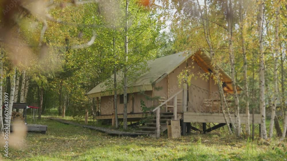 Beautiful house on stilts in a camping in the woods among the birches on a bright sunny summer or autumn day. A house in the forest. Recreation in the wild. Life away from the big city. 4k footage Beautiful house on stilts in a camping in the woods among the birches on a bright sunny summer or autumn day. A house in the forest. Recreation in the wild. Life away from the big city. 4k footage