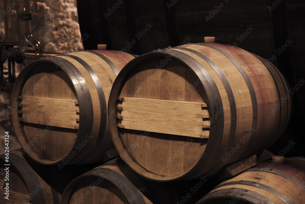 Oak wood barrels in dark winery interior, close up