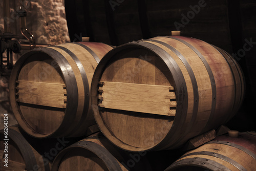Oak wood barrels in dark winery interior, close up