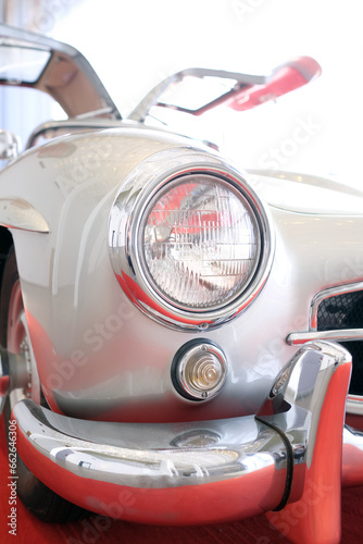 Detail of a classic car with wing doors with borders disappearing into the bright light