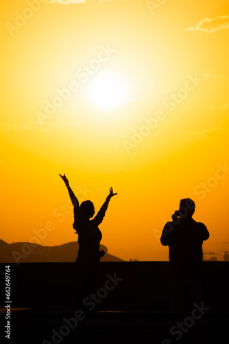 Sunset and lovers. Woman and man against the backdrop of sunset. Orange sky and sun