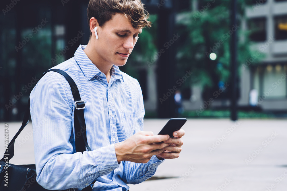 Young businessman in wireless headphones chatting on phone outdoors Young businessman in wireless headphones chatting on phone outdoors