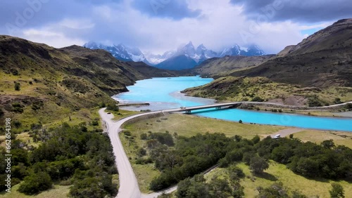Drone flight in Patagonia, Chile and Argentina, with views of crystal blue waters and snow covered mountains and a bridge connecting mountain landscapes. photo
