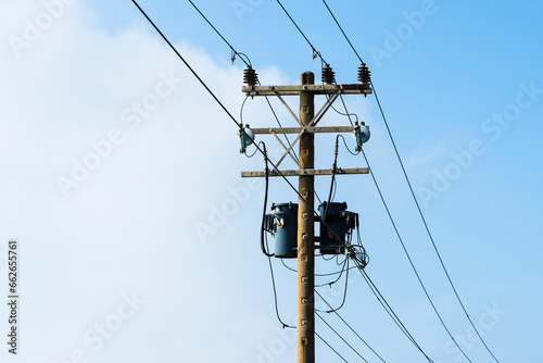 View of Telephone poles with blue sky and white clouds as a background