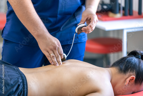 Woman receiving myostimulation treatment in physical therapy clinic.
