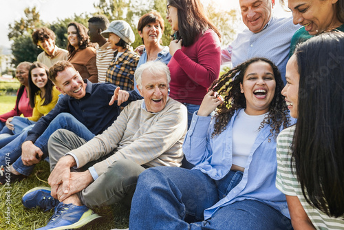 Group of multigenerational people having fun together - Multiracial friends of different ages smiling outdoor - Main focus on african curvy girl face photo