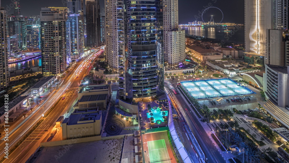 Panoramic view of the Dubai Marina and JBR area and the famous Ferris Wheel aerial night timelapse