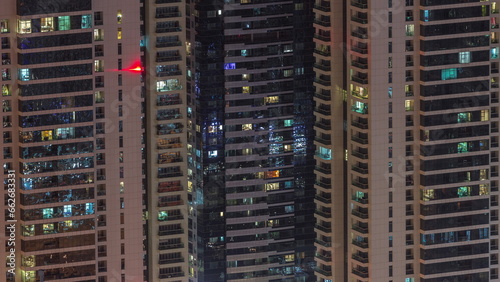 Light in windows of modern towers. Exterior of apartment building at night with glowing windows timelapse.