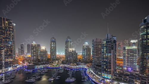 Panorama showing Dubai marina tallest skyscrapers and yachts in harbor aerial night timelapse. #662683586
