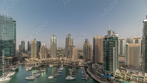 Panorama showing Dubai marina tallest skyscrapers and yachts in harbor aerial timelapse. © neiezhmakov
