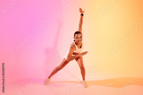 Cheerful active young latin lady in sportswear running, doing exercises for body