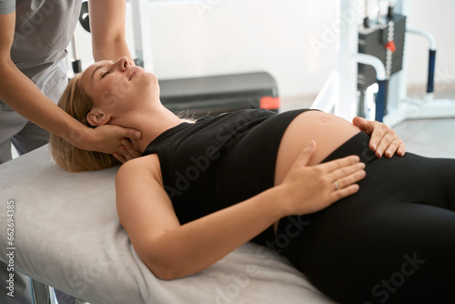 Massage therapist conducts a manual therapy session for pregnant woman